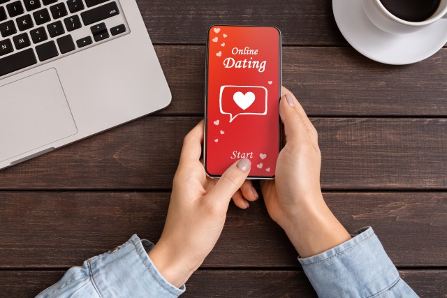 woman holding a smartphone with dating app